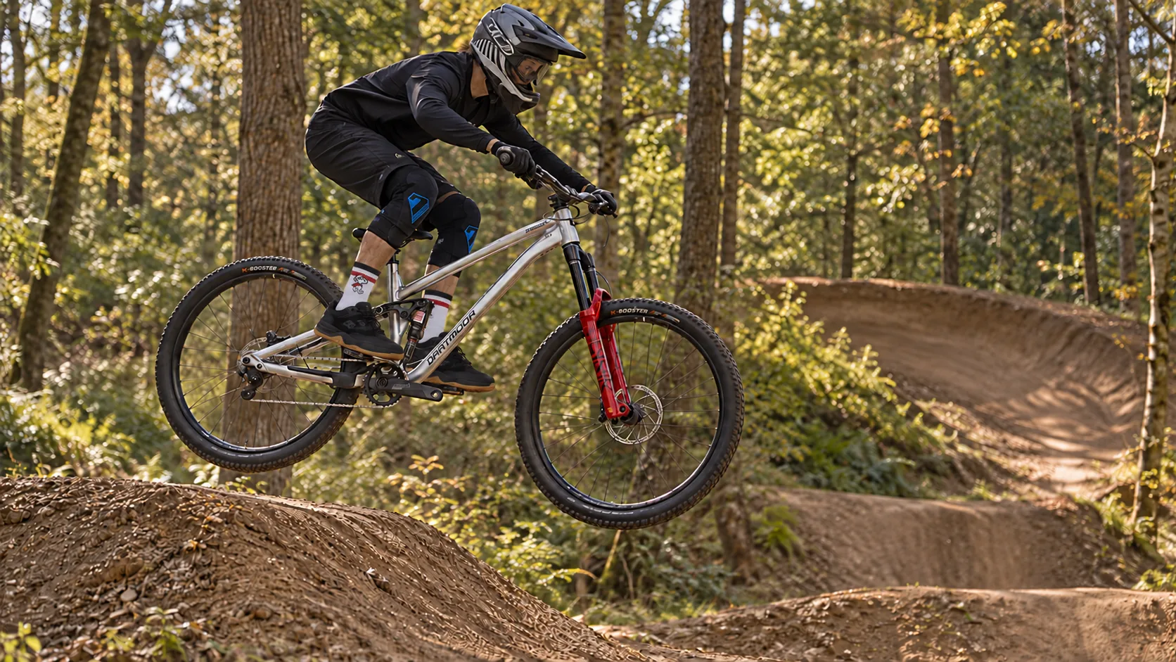 Rider na rowerze MTB podczas skoku na leśnej trasie